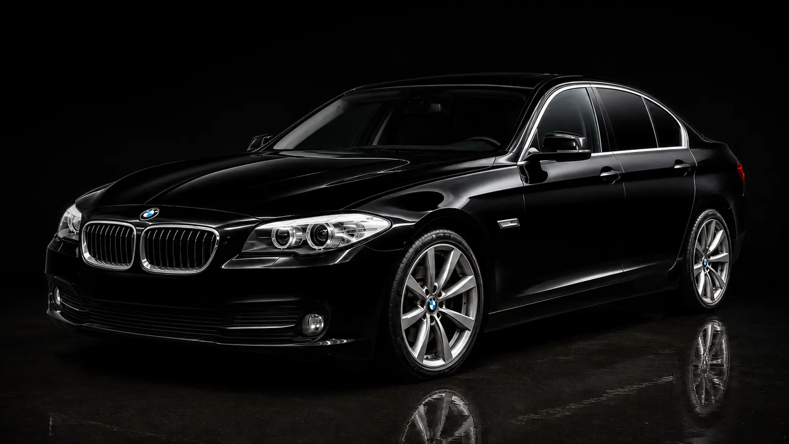 The same BMW 5 Series after correction — deep, mirror-clear gloss reflecting a clean studio light.